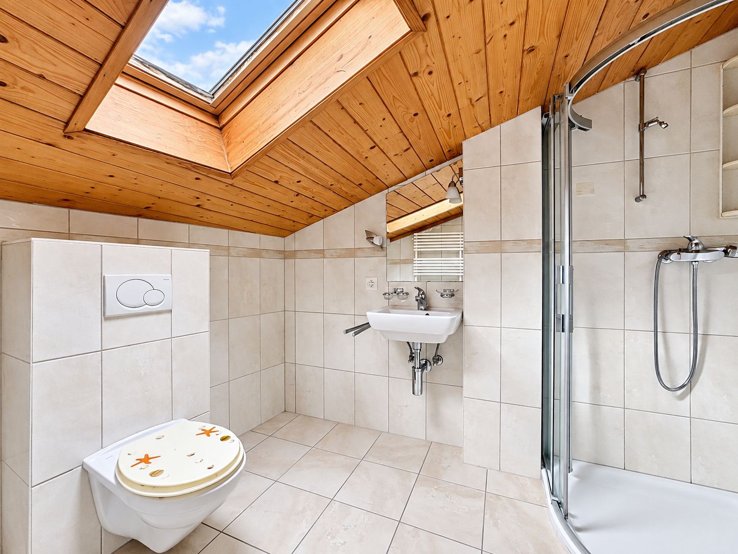 La salle de douche de l'étage, sous la fenêtre de toit.