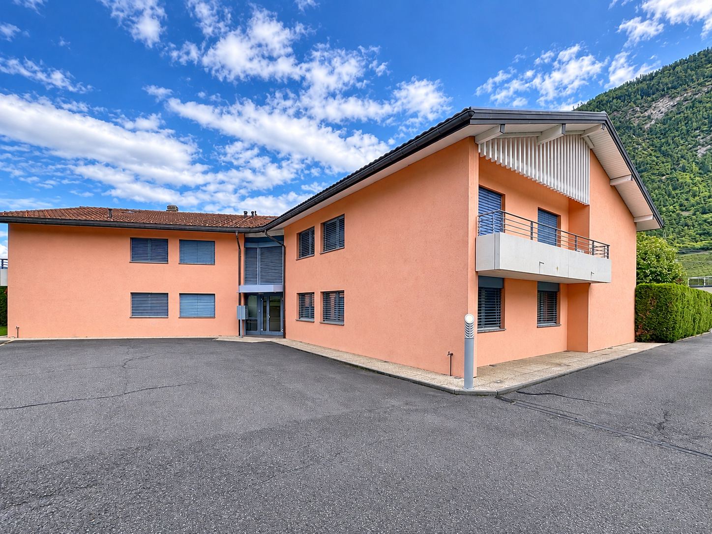 Le bâtiment côté cour, avec balcon et façade crépie.